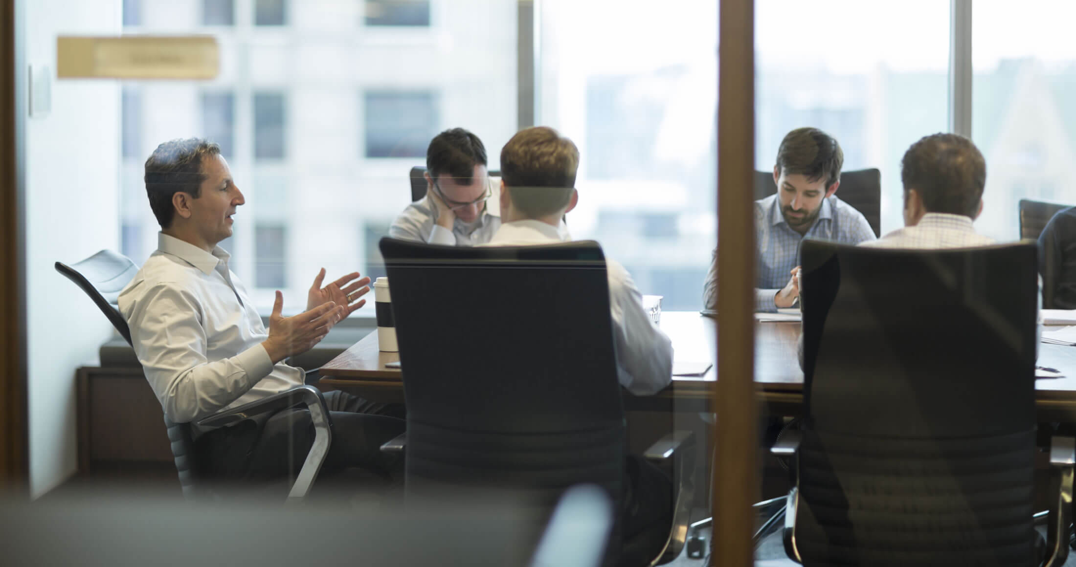 David Herro and the team meeting in a conference room.