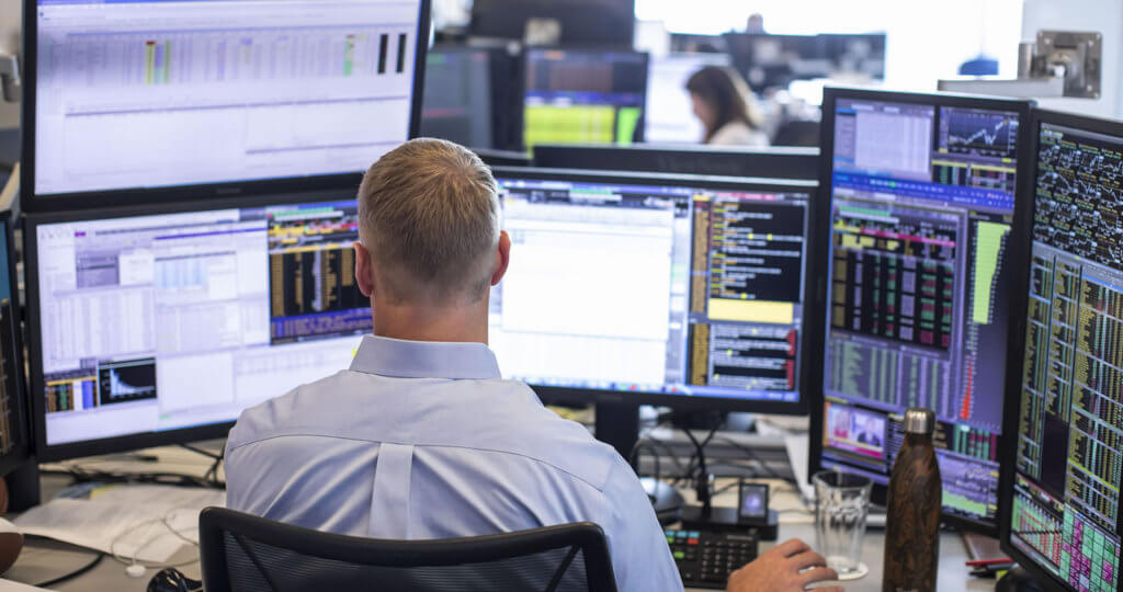 Trading desk with multiple computer screens image