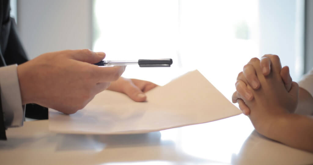 Two people at a desk signing documents